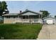 Charming home featuring a cozy porch, stone accents and a detached garage, perfect for comfortable living at 4908 Elmhurst Dr, Indianapolis, IN 46226