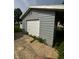 Detached garage with white door, concrete slab, and light gray siding at 4908 Elmhurst Dr, Indianapolis, IN 46226