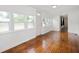 Bright living room with gleaming hardwood floors and plenty of natural light from multiple windows at 517 N Leland St, Fortville, IN 46040