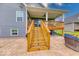 Wooden stairs leading to a cozy back porch with comfortable seating and a serene view at 5199 Green Valley Ln, Noblesville, IN 46062