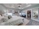Light-filled bedroom showcasing tray ceilings, wood floors, neutral décor, and a spacious walk-in closet at 5199 Green Valley Ln, Noblesville, IN 46062