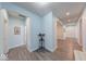 Bright hallway with wood floors, trimmed archways, and a decorative table with red flowers at 5199 Green Valley Ln, Noblesville, IN 46062