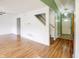 Open-concept living room with wood flooring, a staircase, and views into other rooms at 5234 Melbourne Rd, Indianapolis, IN 46228