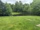 A picturesque pond is surrounded by lush greenery and a black chain link fence at 5234 Melbourne Rd, Indianapolis, IN 46228
