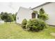 Side yard with trees and shrubs; partially fenced at 5234 Melbourne Rd, Indianapolis, IN 46228