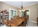 Spacious dining room features a large wooden table, chandelier, and access to other living areas, perfect for entertaining at 5538 N 700 W, McCordsville, IN 46055