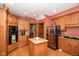 Well-lit kitchen boasts an island, stainless steel appliances, and custom wood cabinetry at 5538 N 700 W, McCordsville, IN 46055