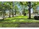 Large backyard with mature trees, a white fence, and a clear view of the house and surrounding landscape at 5922 Broadway St, Indianapolis, IN 46220