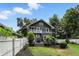 Exterior of home with landscaped yard featuring a white fence and a deck with outdoor furniture at 5922 Broadway St, Indianapolis, IN 46220