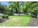 Lush backyard with mature trees and manicured lawn, providing a serene and private outdoor setting at 5922 Broadway St, Indianapolis, IN 46220