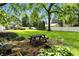 Brick patio featuring a picnic table in a landscaped backyard with lush lawn and mature trees at 5922 Broadway St, Indianapolis, IN 46220