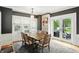 Elegant dining room featuring dark gray walls, natural light, wood table, and backyard access at 5922 Broadway St, Indianapolis, IN 46220