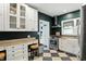 Stylish kitchen showcasing white cabinetry, granite countertops, and black and white flooring at 5922 Broadway St, Indianapolis, IN 46220