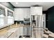 Contemporary kitchen featuring stainless steel appliances, white cabinets, and granite countertops at 5922 Broadway St, Indianapolis, IN 46220