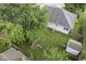 Aerial view of the backyard featuring mature trees, a playground, and a shed on a sunny day at 5986 Regency Dr, Columbus, IN 47203