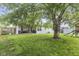 Expansive backyard with mature trees, patio seating, and playground for outdoor enjoyment at 5986 Regency Dr, Columbus, IN 47203