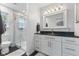Bright bathroom featuring white vanity, black countertop, glass shower, and modern fixtures at 5986 Regency Dr, Columbus, IN 47203