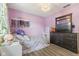 Bright bedroom with lavender walls, hardwood floors, and an ornate chandelier at 5986 Regency Dr, Columbus, IN 47203
