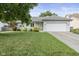 Charming single-story home with a well-manicured lawn and attached two-car garage on a sunny day at 5986 Regency Dr, Columbus, IN 47203