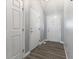Bright hallway with wood-look floors leading to a white front door with glass insert at 5986 Regency Dr, Columbus, IN 47203