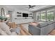 Bright living room featuring hardwood floors, a ceiling fan and a built-in entertainment center with shelving at 6536 Apperson Dr, Noblesville, IN 46060
