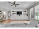 Living room featuring hardwood floors, a ceiling fan, built-in entertainment center and large windows at 6536 Apperson Dr, Noblesville, IN 46060