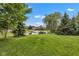 Expansive backyard view with a pond and fountain, surrounded by trees and lush greenery at 705 Ridge Gate Dr, Brownsburg, IN 46112