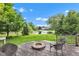 Wooden deck with seating and a fire pit, overlooking a backyard pond and lush greenery at 705 Ridge Gate Dr, Brownsburg, IN 46112