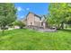 Spacious backyard featuring a large deck area with outdoor seating near a two-story brick house at 705 Ridge Gate Dr, Brownsburg, IN 46112