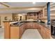 Basement bar featuring wood cabinetry, granite countertops, and a convenient sink area, ideal for hosting at 705 Ridge Gate Dr, Brownsburg, IN 46112