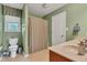 This bathroom features a shower with curtain, a toilet, and sink with wood-stained cabinets at 705 Ridge Gate Dr, Brownsburg, IN 46112