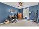Well-lit bedroom featuring neutral carpet, a dark blue accent wall, and a ceiling fan at 705 Ridge Gate Dr, Brownsburg, IN 46112