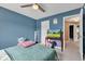Bedroom with blue walls featuring a ceiling fan and doorway leading to another room at 705 Ridge Gate Dr, Brownsburg, IN 46112