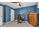 Well-lit carpeted bedroom featuring neutral carpet, a dark blue accent wall, and a ceiling fan at 705 Ridge Gate Dr, Brownsburg, IN 46112