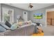 Inviting bedroom with ceiling fan, neutral-toned walls, plush carpeting, and a television at 705 Ridge Gate Dr, Brownsburg, IN 46112