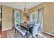 Comfortable dining room with a large table, modern lighting fixture, and views of the backyard through sliding glass door at 705 Ridge Gate Dr, Brownsburg, IN 46112