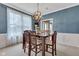 Formal dining room features elegant wainscoting, modern light fixture, and a wooden table with seating for six at 705 Ridge Gate Dr, Brownsburg, IN 46112