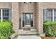 Elegant front entryway with detailed glass door, sidelights, decorative accents, and lush green shrubs at 705 Ridge Gate Dr, Brownsburg, IN 46112