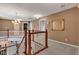 Second floor hallway showcasing hardwood railings, neutral paint, carpeted floor, stylish light fixtures, and framed mirror at 705 Ridge Gate Dr, Brownsburg, IN 46112
