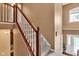 An elegant staircase with white railings and a wooden banister leads upstairs, illuminated by a window near the front door at 705 Ridge Gate Dr, Brownsburg, IN 46112