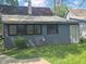 View of the house exterior with gray siding, visible back entrance and chimney at 711 W Centennial Ave, Muncie, IN 47303