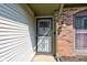 Close-up of the front door, showing the storm door, siding, brick and light fixture at 7150 Eagle Cove Dr, Indianapolis, IN 46254
