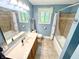 Blue bathroom with a window, tiled shower and vanity sink at 725 N State Road 75, Lebanon, IN 46052