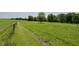 Picturesque farm field with a fence and distant trees, offering a serene rural escape at 725 N State Road 75, Lebanon, IN 46052