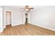Open bedroom with wood-look floors, ceiling fan, and multiple doors to other rooms at 7639 Foxglove Ln, Noblesville, IN 46062