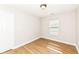Small bedroom with wood-look floors, a window and a white door at 7639 Foxglove Ln, Noblesville, IN 46062