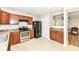 Bright kitchen with wood cabinets, black appliances, and pass-through to another room at 7639 Foxglove Ln, Noblesville, IN 46062