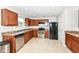 Well-lit kitchen featuring wooden cabinets, stainless steel appliances, and neutral countertops at 7639 Foxglove Ln, Noblesville, IN 46062