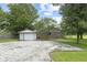 Backyard featuring a brick house, a white shed and a parking area covered in gravel at 7928 Vontress St, Coatesville, IN 46121