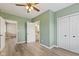 This is a bedroom with light green walls, hardwood flooring, and white doors leading to a bathroom and closet at 7928 Vontress St, Coatesville, IN 46121
